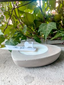 Świeca sojowa w betonowym sercu. Betonowy, szary pojemnik z ekologicznym woskiem sojowym.