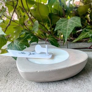 Świeca sojowa w betonowym sercu. Betonowy, szary pojemnik z ekologicznym woskiem sojowym.