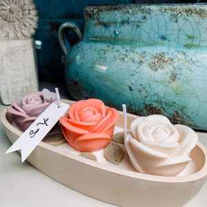 Świeca dekoracyjna trzy róże z wosku sojowego w beżowym dużym pojemniku z gipsu.