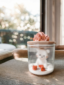 Świeca sojowa z misiem i sercami w szkle ryflowanym.