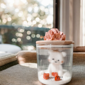Świeca sojowa z misiem i sercami w szkle ryflowanym.