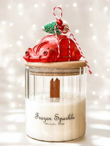 Świeca dekoracyjna Frozen Sparkle w szklanym pojemniku z bambusowym wieczkiem. Z dekoracją świąteczną - czerwony garbus z choinką i dzwoneczkiem.